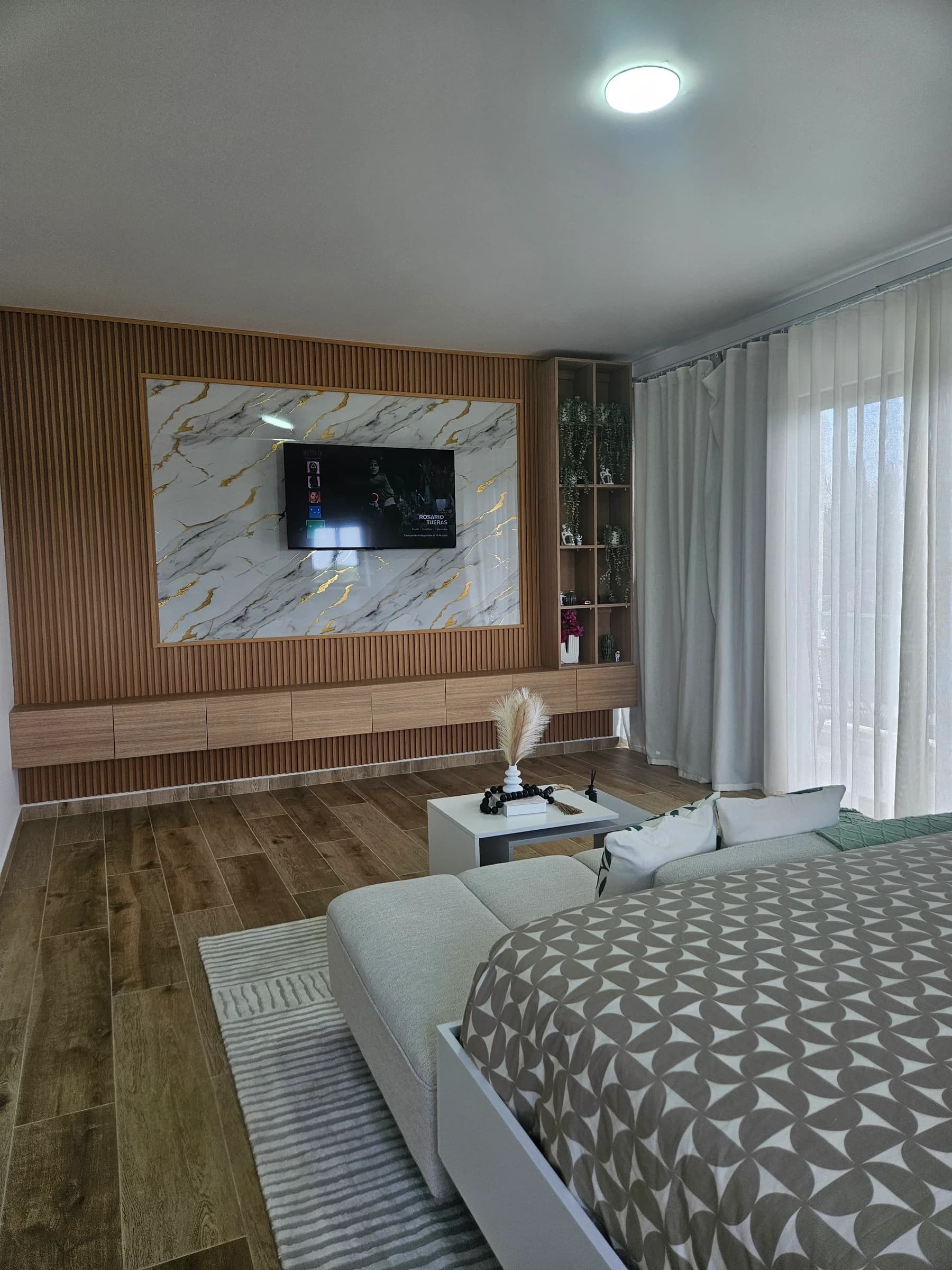 Panel de TV en listones de madera con incrustación de mármol.